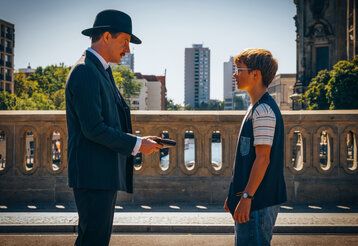 Szene aus dem Film Emil und die Detektive, Emil und ein Mann stehen auf einer Brücke, der Mann hält ein Portemonniae in der Hand
