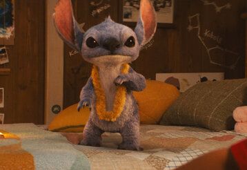 Szene aus dem Film Lilo und Stitch, Stitch steht auf einem Bett und guckt in die Kamera