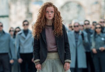 Szene aus dem Film Momo, ein Mädchen mit roten Locken steht im Vordergrund, hinter ihr: eine Menschenmenge graugekleideter Personen