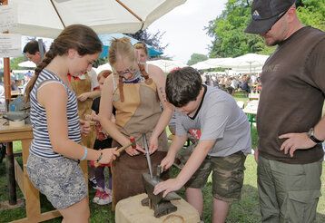 Flachsmarkt Krefeld: Kinder hämmern auf Metall in einem Amboss