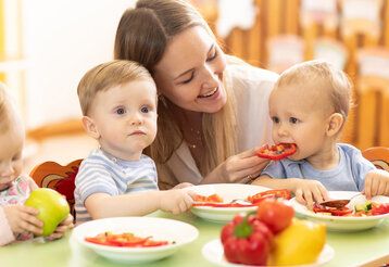 Frau mit Kleinkindern beim Essen