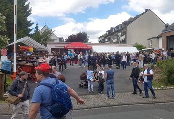 Auf dem Gelände der freiwilligen Feuerwehr Unterbach stehen Menschen zusammen und feiern