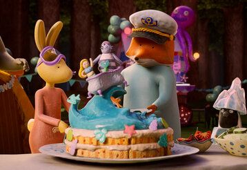Animationsfilm, Hase und Fuchs stehen zusammen, vor ihnen steht eine bunte Torte