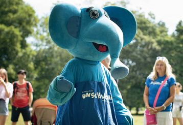 Blauer Elefant des Kinderschutzbundes im Park, im Hintergrund Leute