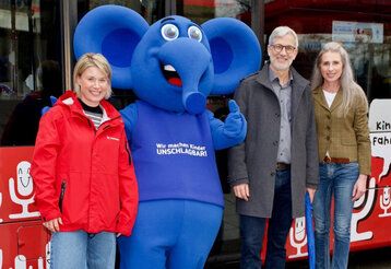 Gina Niemeier, Blauer Elefant, Hauke Duckwitz und Vera Vitzthum-Gross stehen vor einer Rheinbahn