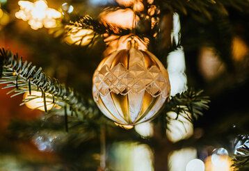 Goldene Christbaumkugel am Baum