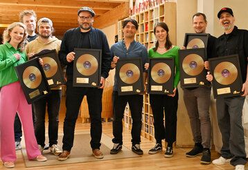 Das Tonies-Team hält goldene Schallplatten in den Händen.  Andrea Schütze (Buch), Matthias Kloppe (Musik), Tom Steinbrecher (Musik), Markus Langer (CCO tonies), Tobias Leluschko (Musik), Charlotte Kirstein (PM tonies), Kay Poppe (Produktion), Alexander Rieß (Produktion).