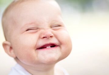 Grinsendes Baby mit zwei Zähnen Unterkiefer
