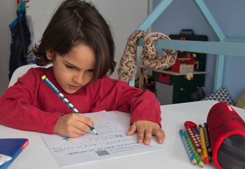Grundschulkind füllt Arbeitsblatt aus
