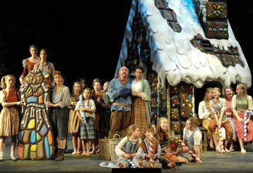 Auf der Bühne der Deutschen Oper am Rhein: Dartseller vor dem Lebkuchenhaus