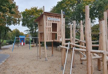 Spielplatz mit Holzhaus und Klettergerät