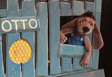 Hundepuppe guckt aus einer Bretterbude