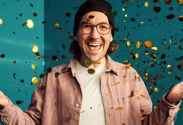 Porträt vom Musiker herrH, vor türkisem Verlauf, Konfetti fleigt durch die Luft