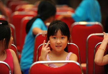 Mädchen sitzt in einer Stuhlreihe