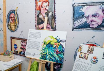 Ecke eines Ausstellungsraumes im Oberschlesischen Landesmuseum mit grünen Sitzsäcken, zwei Staffelein, auf denen aufgeschlagene Bücher liegen