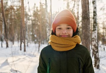 Junge im verschneiten Wald