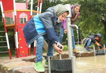 Junge spielt auf Wasserspielplatz in Garath
