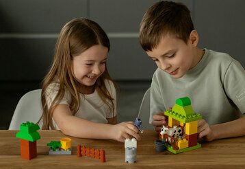Mädchen und Junge spielen mit legoartigen Bauklötzen