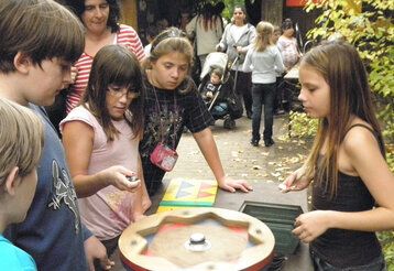 Kinder spielen eine Art Roulette auf dem Abenteuerspielplatz Eller