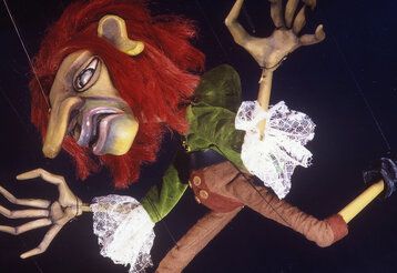 Marionette Klein Zaches genannt Zinnober vor schwarzem Hintergrund