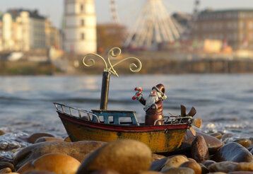 Kleine Nikolausfigur am Rheinufer, im Hintergrund Schlossturm und Burgplatz