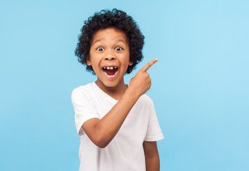 Kleiner schlauer junge zeigt mit dem Zeigefinger - Studioaufnahme