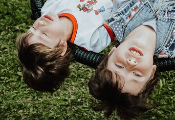 zwei Jungs liegen auf einer Art Hängematte, Perspektive: Köpfe von oben im Bild