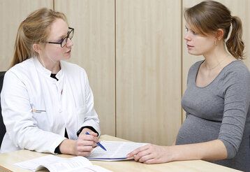 Eine Ärztin und eine Schwangere unterhalten sich
