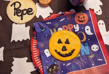 Halloweenartig gedeckter Tisch von oben mit zwei Halloweenplätzchen