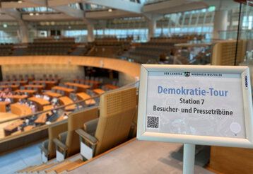 Plenarsaal des Landtags NRW mit Schild bei der Besucherführung