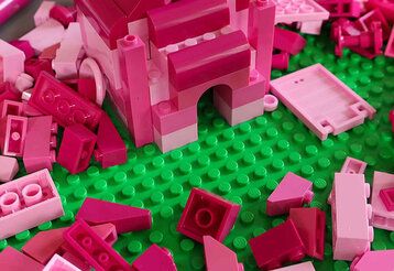 Pinke Legosteine auf grüner Bauplatte