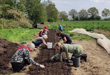 Leute arbeiten auf einem Acker