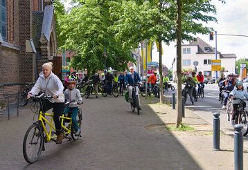 Leute fahren mit Fahrrädern durch Büderich