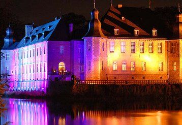 Das bunt beleuchtete Schloss Dyck bei Nacht während des Lichtfestivals.