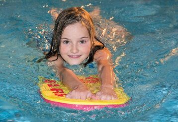 Mädchen im Wasser mit Schwimmhilfe