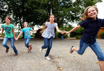 Mädchen rennen lachend über den Schulhof