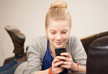 Mädchen daddelt am Smartphone