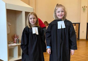 Zwei Mädchen mit Talaren in der Spielkirche