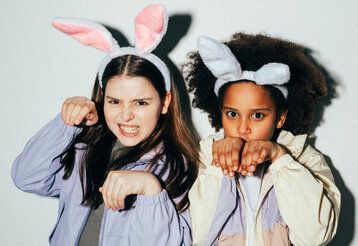 Porträtvon zwei Mädchen, die Haarreifen mit Plüsch-Hasenohren tragen