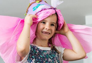 Mädchen mit rosa Schultüte auf dem Kopf