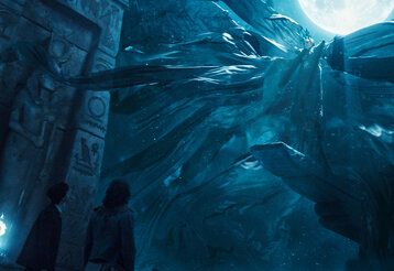 Zauberhaftes Wesen bei Vollmond in einer Kultstätte, zwei Menschen gucken hoch