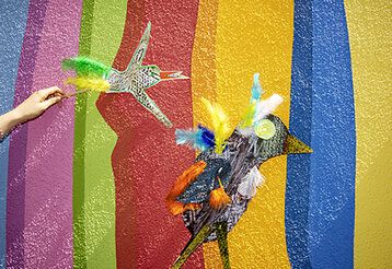 gebastelte Papiervögel vor bunter Wand