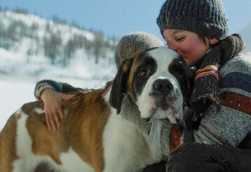 Szene aus dem Film Mein Freund Barry, ein Junge umarmt einen Bernhardiner, im Hintergrund Schneelandschaft