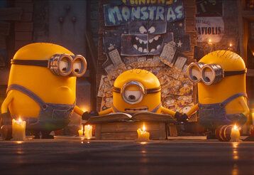 Szene aus dem Film Minions und Monster, drei Minions lesen in einem alten Buch
