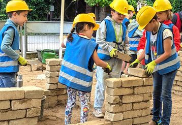 Kinder bauen  eine Mauer auf der Mitmach-Baustelle im Kindermuseum Mutreiferei