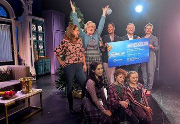 Gruppenbild, Darsteller:innen und Spender:innen bei der Mrs Doubtfire Spendenaktion auf der Bühne