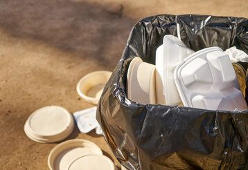 Überfüllte Mülltonne auf der Straße. Einweg-Lebensmittelbehälter. Umweltverschmutzung.