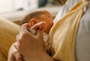 Neugeborenes trinkt an der Brust der Mutter