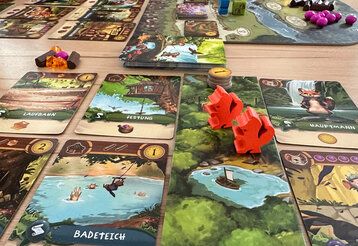 Spielkarten und Figuren des Spiels My Lil’ Everdell auf einem Tisch