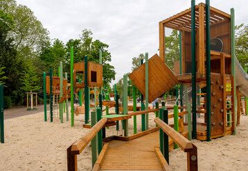 Der große Kinderspielplatz im Düsseldorfer Hofgarten ist wiedereröffnet. Der in Grüntönen gestaltete Spielplatz bietet zahlreiche Spiel-Stationen für jüngere als auch ältere Kinder. Das prägende Hauptspielgerät ist als großer Parcours gestaltet